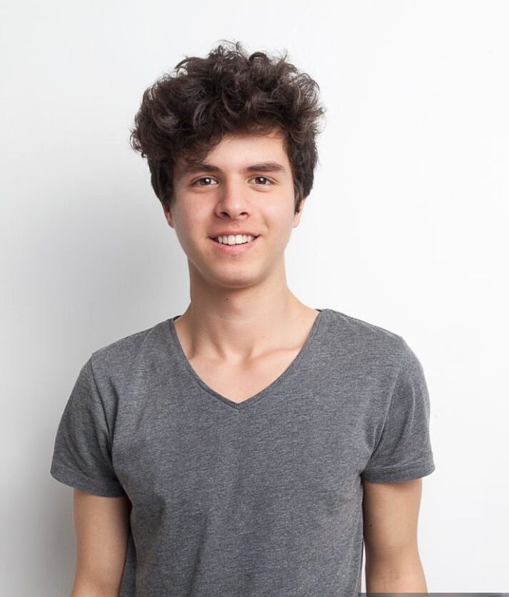 male teenager smiling on white background